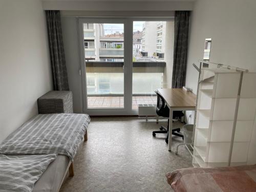 1 dormitorio con cama, escritorio y ventana en Nice, cosy and central apartment with big balcony en Karlsruhe