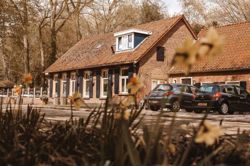 two cars parked in front of a brick building at Hotel 't Welink in Dinxperlo