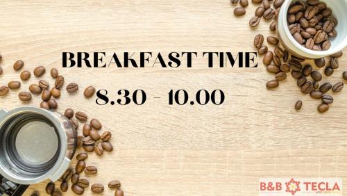 Una mesa de madera con granos de café y una taza de café. en B&B Tecla, en Nápoles