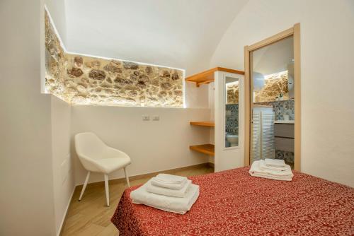 una camera con letto, sedia e specchio di Dentro le mura ad Alghero