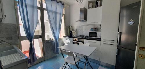 una cocina con encimera y mesa. en Appartamento in Piazza Italia, en SantʼAntìoco