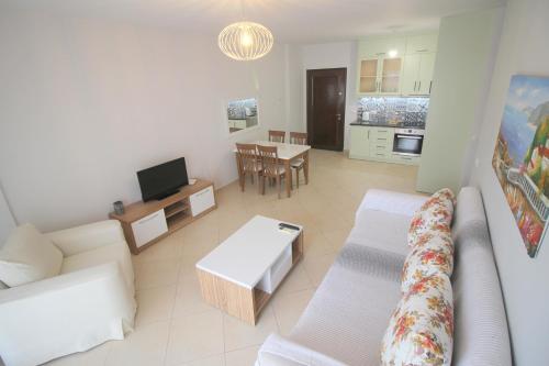ein Wohnzimmer mit einem Sofa und einem Tisch in der Unterkunft Kosta's Apartment in Sarandë