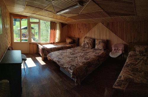 ヴェルホヴィナにあるUsadba Yuryevykhの木製の部屋にベッド2台が備わるベッドルーム1室