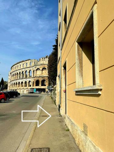 a building with a arrow on the side of a street at Apartment Amfiteatar in Pula