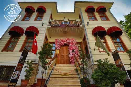 a yellow house with flowers on the front door at Ada Palas Buyukada in Buyukada