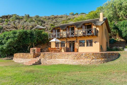 a house on a hill with a stone wall at Tides River Lodge in Malgas