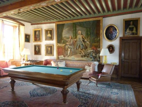 una sala de estar con mesa de billar y una pintura en Chateau du Fraisse en Nouic