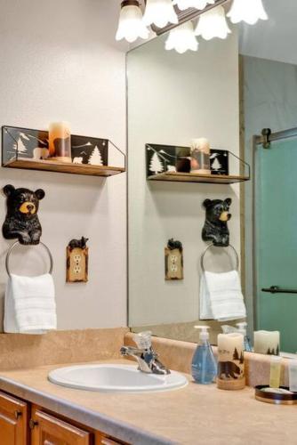 a bathroom with a sink and a large mirror at Soco Serene Cabin in the Heart of Maggie Valley in Maggie Valley