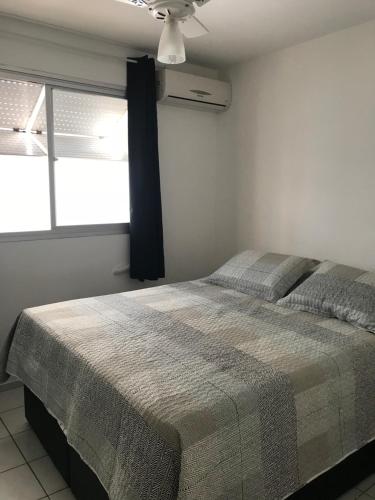 una camera con letto e ventilatore a soffitto di Apartamento Confortavel em Balneário Camboriu a Balneário Camboriú