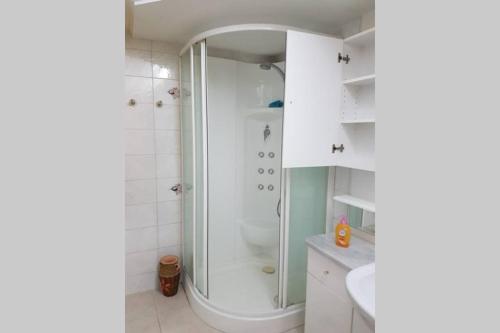 a white bathroom with a shower and a sink at Palma BnB in Maracalagonis