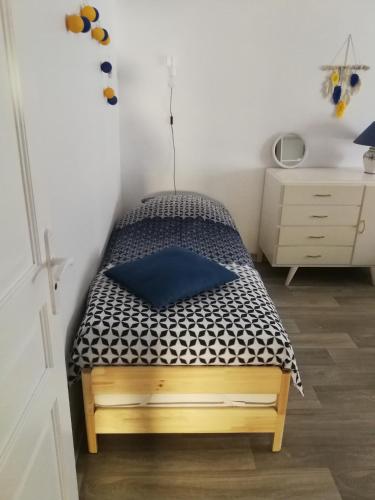 a bedroom with a bed with a blue pillow at Chez Isa et Christophe in Mogeville