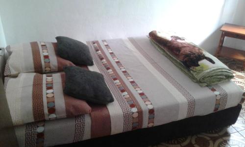 a bed with a blanket and pillows on it at case ti kaf in Saint-Leu