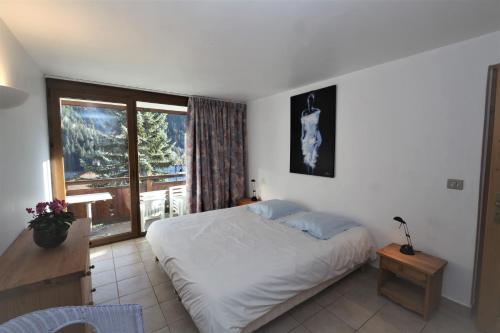ein Schlafzimmer mit einem Bett und einem großen Fenster in der Unterkunft Chalet Bouquetin- Renard in Champagny-en-Vanoise