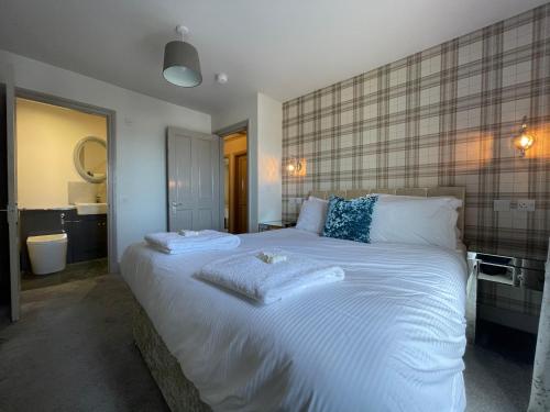 1 dormitorio con 1 cama blanca grande y baño en Apartments No. 19 en Portpatrick