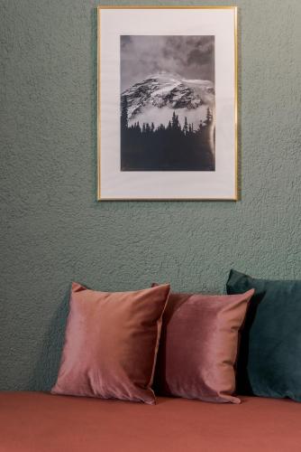 a picture of a snow covered mountain above a couch at Paeonia Arachova in Arachova