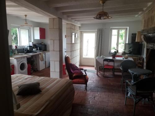 1 dormitorio con 1 cama y cocina con mesa y sillas en Gite la petite pataudiere, en Le Guédéniau