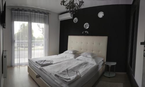 Un pat sau paturi într-o cameră la IKON apartman