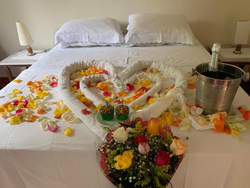 a bed with two hearts and flowers on it at Pousada Penedo in Penedo