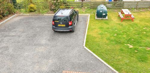 a car parked in a parking lot in a yard at Self catering upper floor flat at Woodend house in Balmacara
