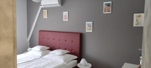 a bed with a red headboard in a bedroom at IKON apartman in Hajdúszoboszló