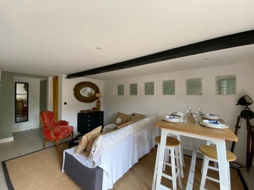 a living room with a couch and a table at Le Jardin de Fileraise Pour un couple in Le Bois-Plage-en-Ré