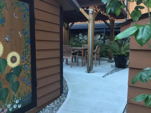 an outside view of a patio with a table and chairs at Nestledown B&B in Halfmoon Bay