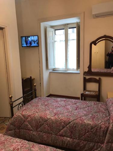 a bedroom with a bed and a mirror and a window at La Casa di Gabry in Valledolmo