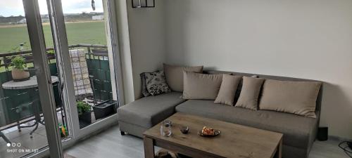 a living room with a couch and a table at Apartament w spokojnej lokalizacji in Cieplewo