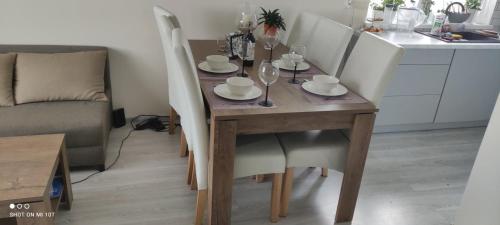 a dining room table with white chairs and a table and a table and chairsktop at Apartament w spokojnej lokalizacji in Cieplewo