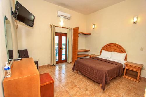 a bedroom with a bed and a desk and a television at Hotel Santa Rita in Guanajuato