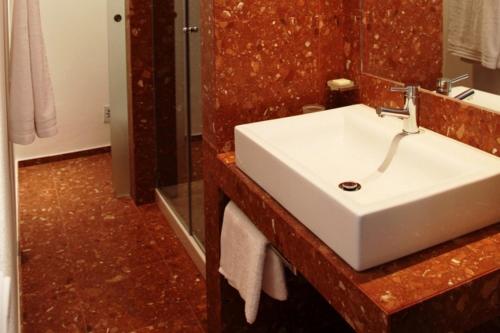 een badkamer met een witte wastafel en een spiegel bij Tavira Home in Tavira