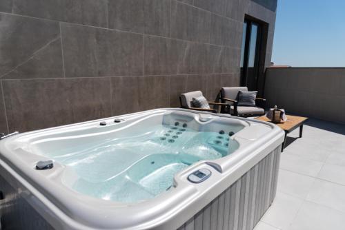 a jacuzzi tub in a room with chairs at Modica Boutique Hotel in Modica