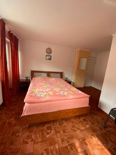 una camera con un letto e una coperta rosa di vila Monski ad Azuga