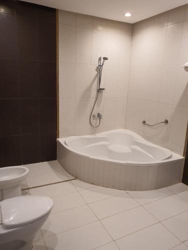a bathroom with a bath tub and a toilet at رميس البخاري in Buraydah