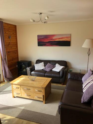 a living room with a couch and a coffee table at Ben Rinnes Lodge Glenlivet Highlands in Auchnastank
