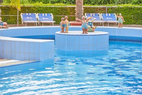 a swimming pool with figurines of people in the water at Ferienwohnung Veronika in Bad Griesbach