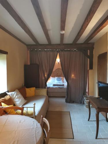 Cette chambre comprend 2 lits, une table et une télévision. dans l'établissement Domaine des Maillets, à Blot-lʼÉglise