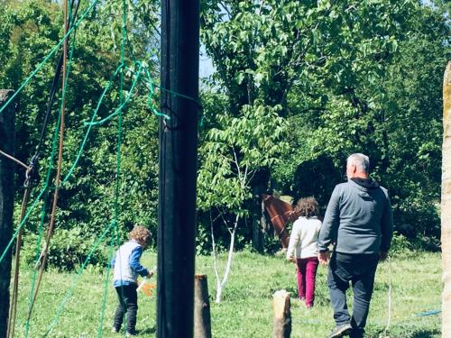 a man and two children standing in a field at Lazuri Keria Family Guesthouse in Khoni