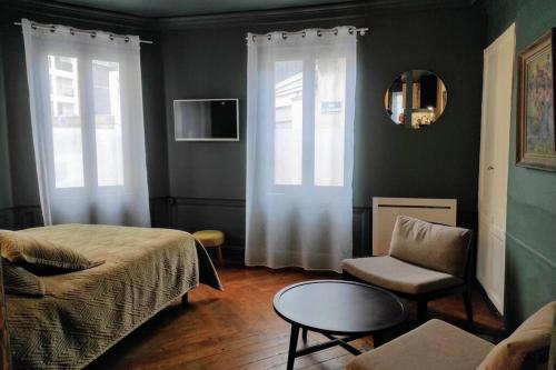 ルーアンにあるGrand Studio de charme Rouen centreのベッドルーム1室(ベッド1台、椅子、テーブル付)