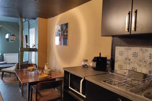 - une cuisine avec un évier et une table dans une chambre dans l'établissement Grand Studio de charme Rouen centre, à Rouen