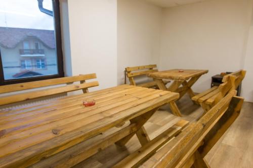 two tables and benches in a room with a window at Viktorijini konaci in Kremna