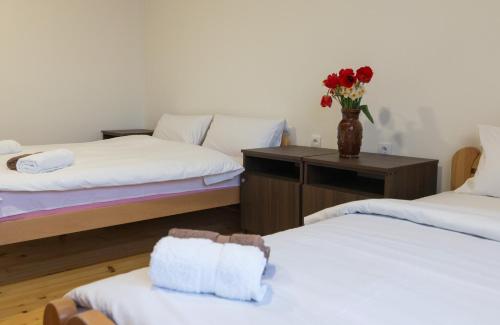 a room with two beds and a vase of flowers at Viktorijini konaci in Kremna