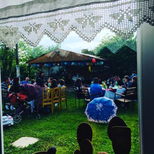 a group of people sitting at tables in the grass at Lazuri Keria Family Guesthouse in Khoni