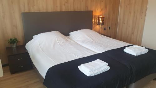 een slaapkamer met een bed met twee handdoeken erop bij Grand Café Goejje voorheen Oranje Hotel in Meijel