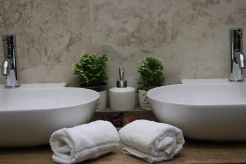 two white sinks in a bathroom with towels at Hotel Regina Margherita in Bordighera