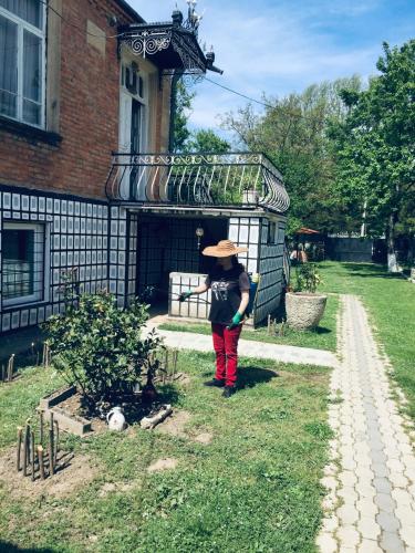a woman standing in front of a house at Lazuri Keria Family Guesthouse in Khoni
