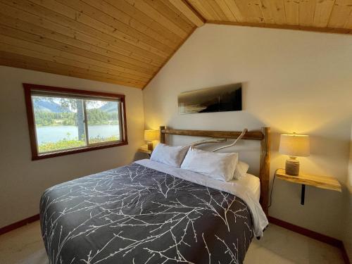 a bedroom with a bed and a window at Private Oceanfront Cabin With Hot Tub Doc Holiday Cabin in Ucluelet