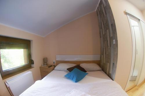 a bedroom with a white bed with a blue pillow at Vila Chess in Belgrade