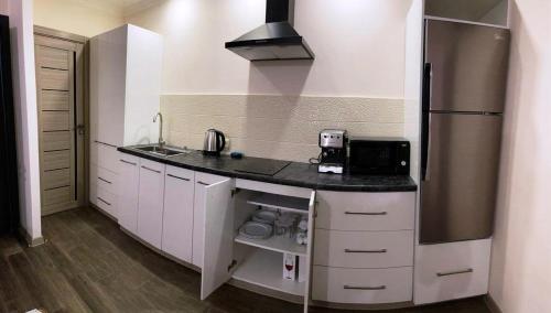 a kitchen with white cabinets and a stainless steel refrigerator at CITY VIEW PENTHOUSE in Yerevan