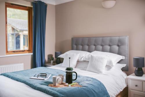 um quarto com uma cama com um cobertor azul em Swifts Return - Apartment with hot tub, sauna and indoor pool (Dartmoor) em Exeter